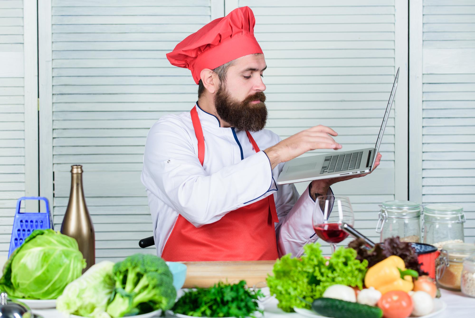 Small production kitchen with chef and laptop